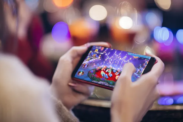 A young woman relaxing with her phone while dynamic casino elements float around her, illustrating the smooth mobile experience offered by the 866JL app.
