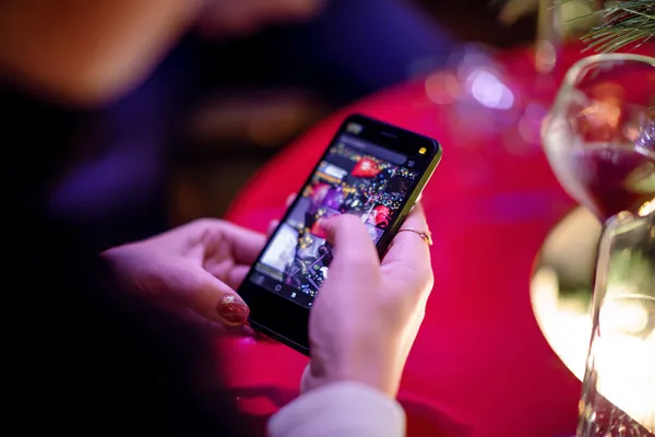 A cheerful woman in traditional clothing using her smartphone during a festive moment, showing how easily the 866JL app fits into everyday life.