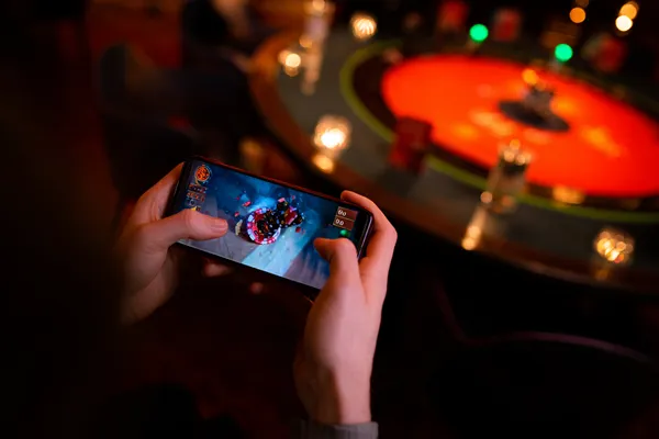 A player using their smartphone during a festive local event, representing 866JL’s fully mobile-friendly casino.